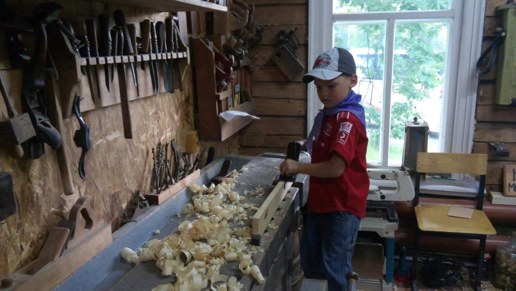 Фёдор производит стружку ручным рубанком.